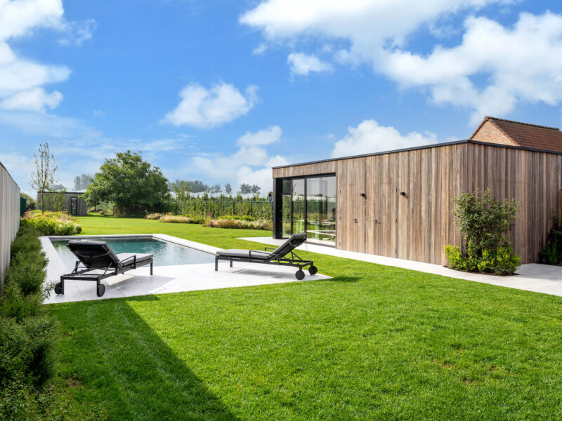 Een moderne tuin met een zwembad en bijgebouw, ontworpen door tuinarchitect Wim Verrezen